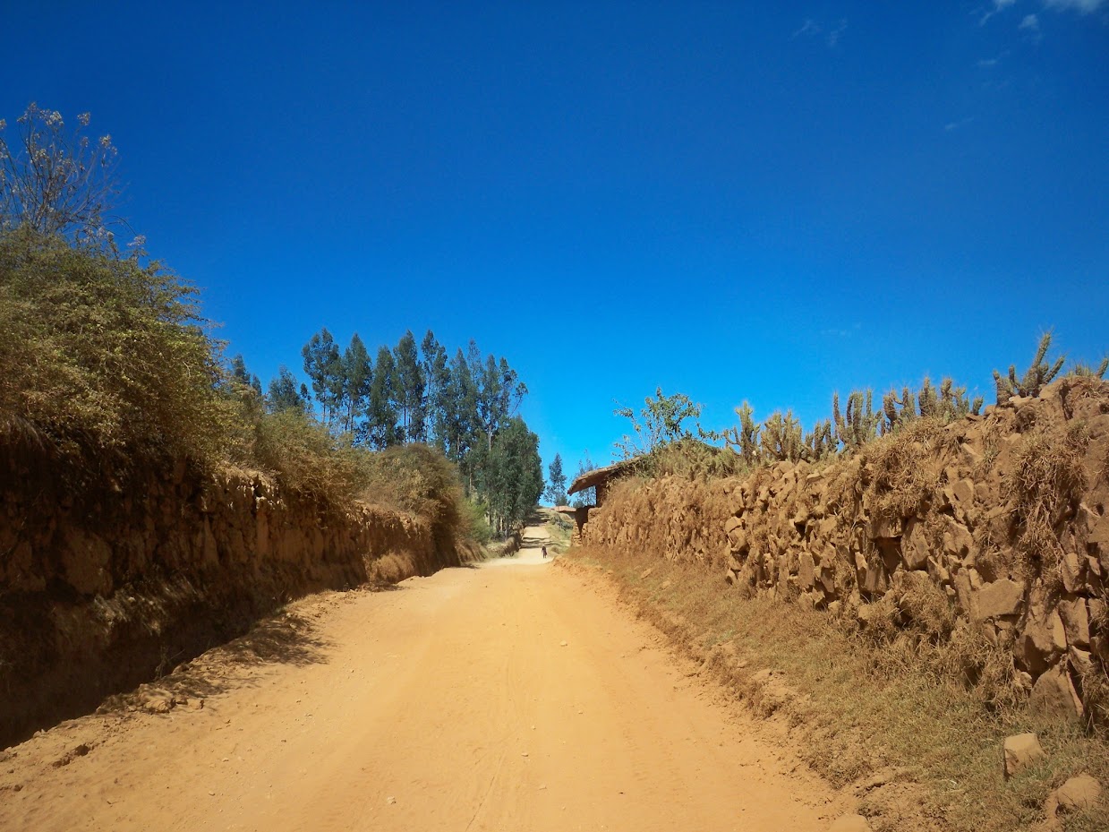 Cycling along a dusty road in Peru with walls on either side
