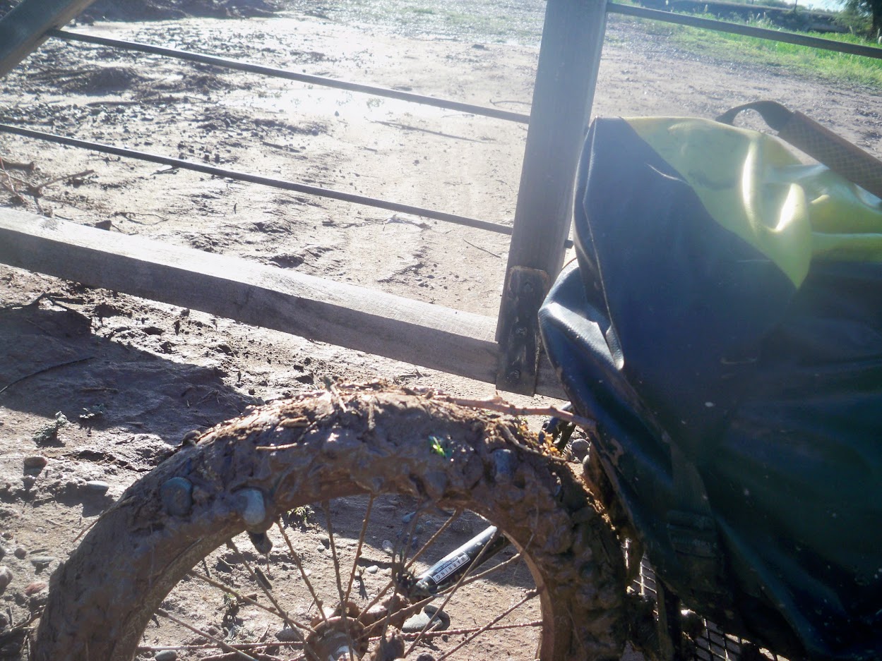 The rear wheel of my Bob cycling trainer covered in mud