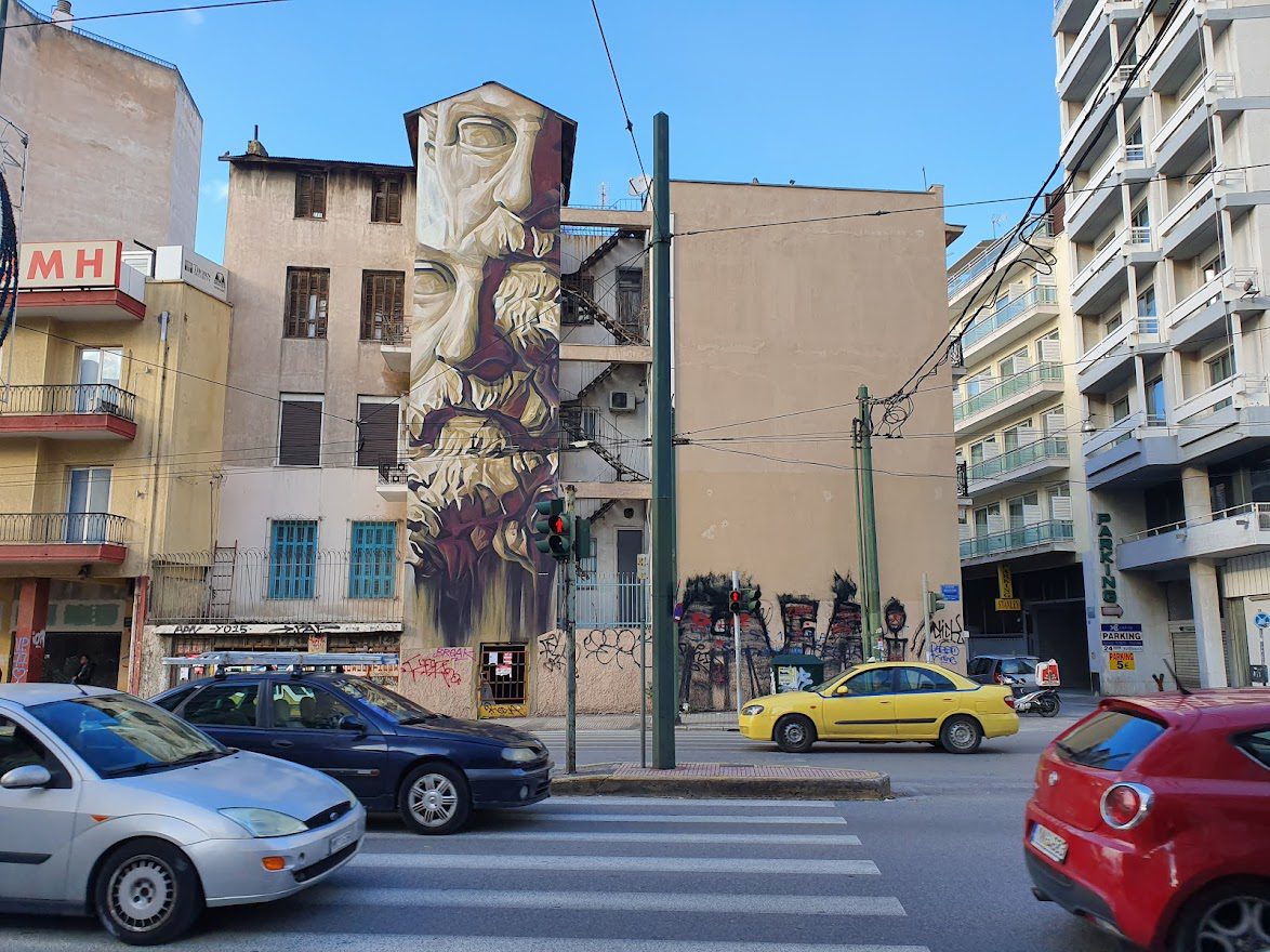 Traffic in Athens with street art in the background