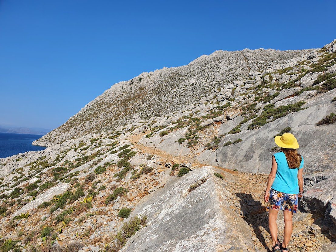 Taking the hiking path to Saint Nicholas beach from Pedi bay in Symi, Greece