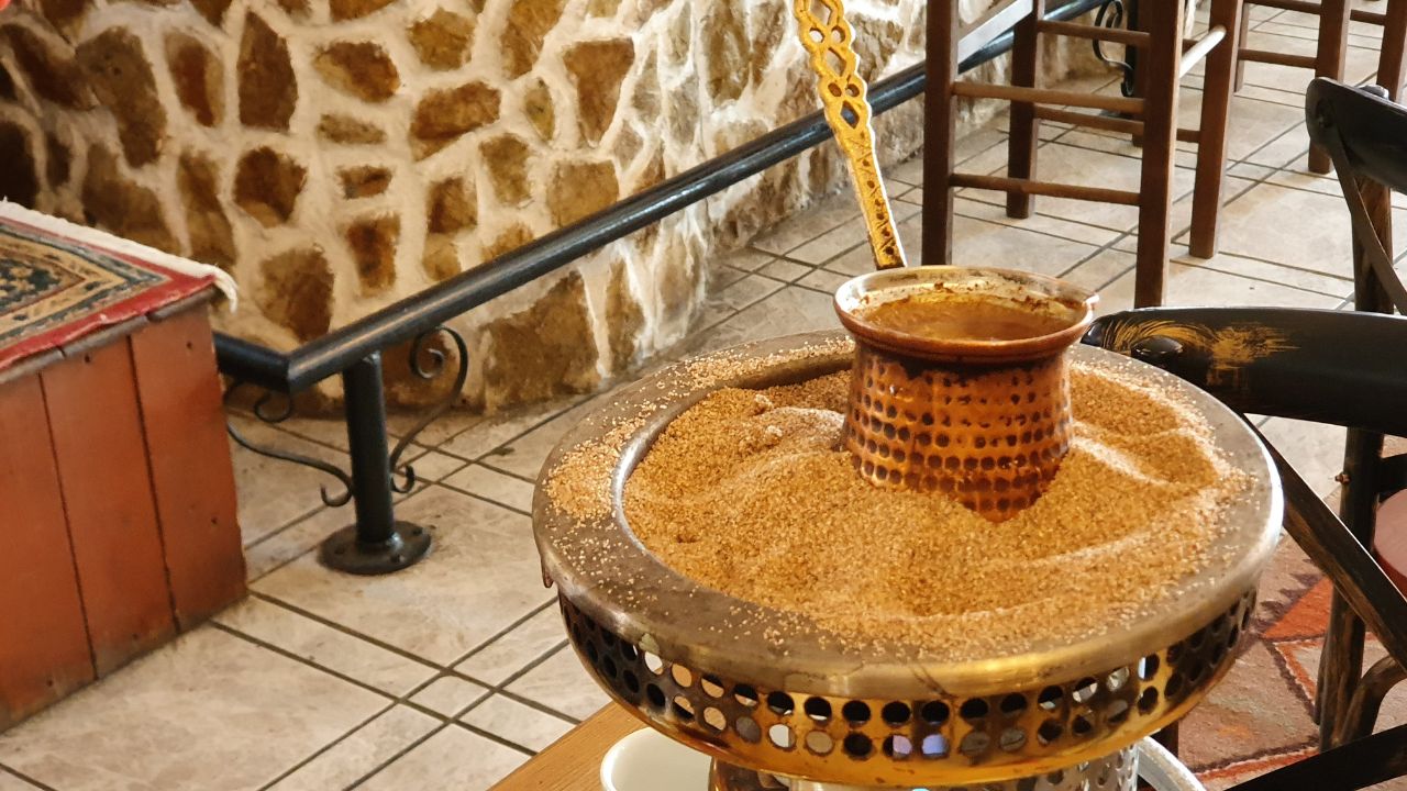 Preparing a traditional Greek coffee on hot sands