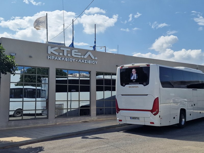 A white Scania coach (fleet number 137, named 'Dimitrios') parked outside the KTEL Herakliou-Lasithiou bus station in Heraklion, Crete.
