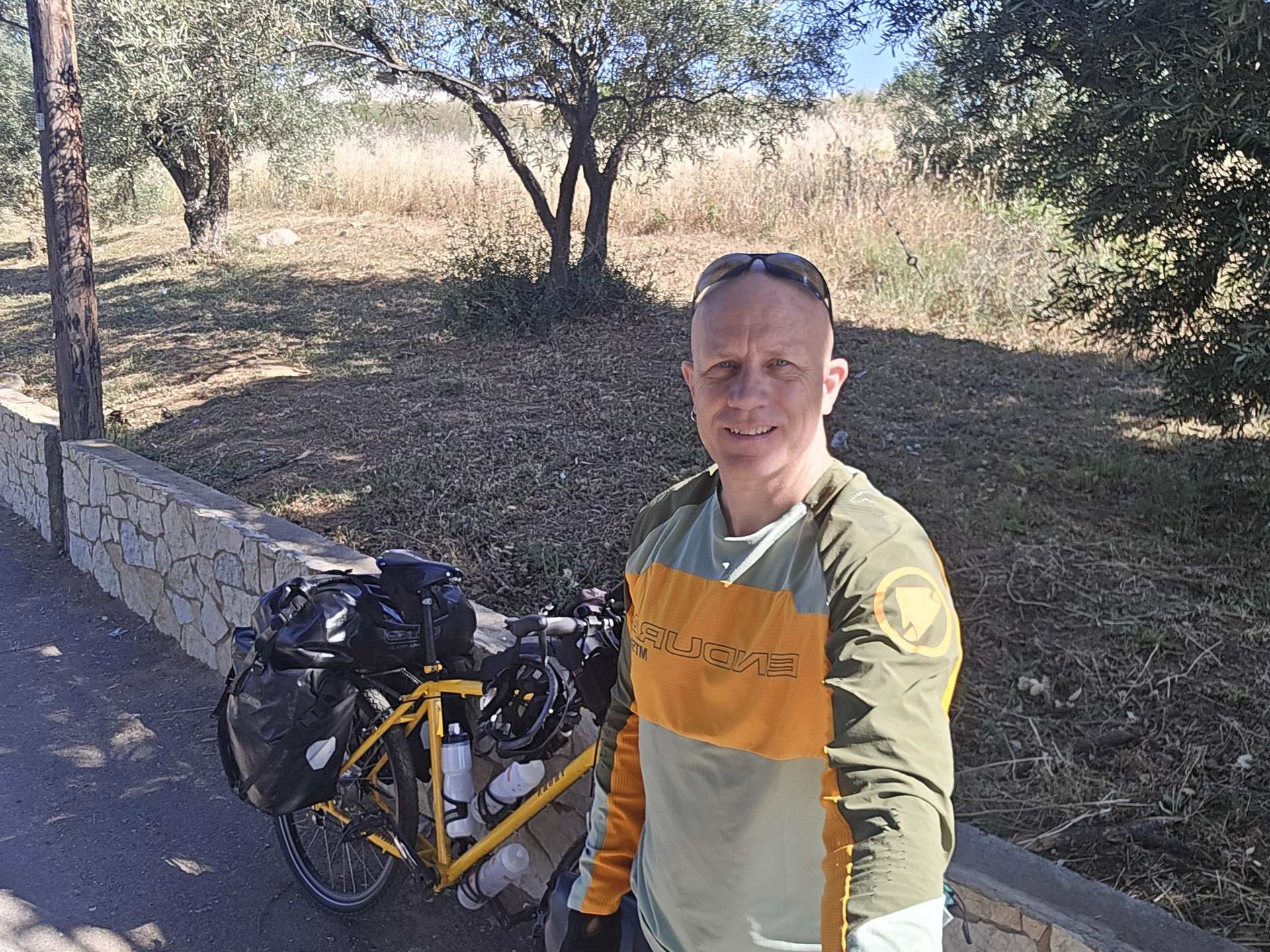 Dave Briggs on day 1 of the bicycle tour, with my Thorn Nomad Mk2 bicycle on a roadside among olive trees in the Greek countryside